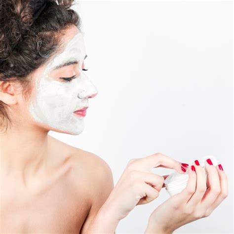 Femme Appliquant Un Masque Facial Sur Son Visage Sur Fond Blanc Photo