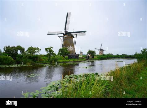 Historic Windmills And A River Flowing By In Kinderdijk Netherlands