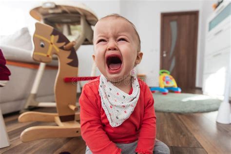 Little Girl Sitting On The Floor At Home And Crying One Year Old Baby