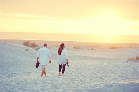 Leisurely Strolls Along The Beach A Mature Couple Going For A Relaxing