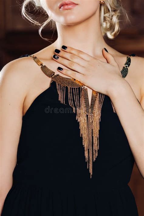 Elegant Black Dress With Gold Jewelry On A Beautiful Sensual Young