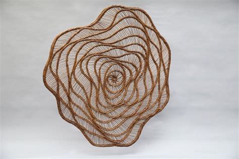 A Wire Sculpture Made To Look Like A Spiral Rose On A White Background