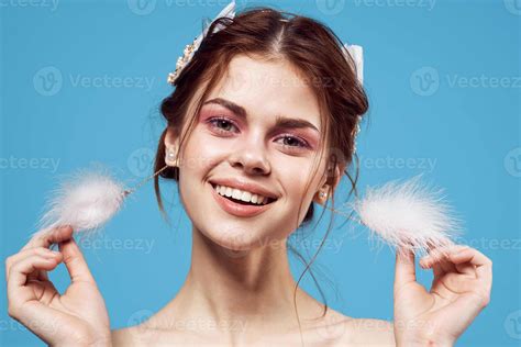 Attractive Woman Naked Shoulders Fluffy Earrings Cosmetics Blue Background Stock Photo