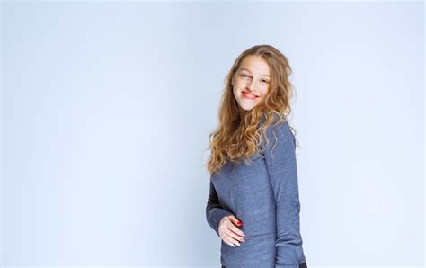 Fille Blonde Aux Cheveux Bouclés Posant En Pull Indigo Photo Gratuite