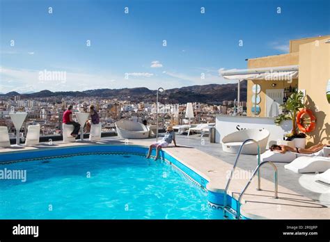 People relax at rooftop swimming pool of AC Hotel Malaga Palacio by ...