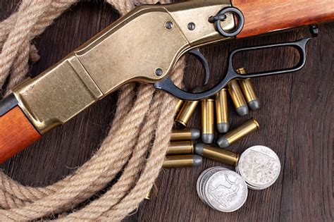 Old West Gun Leveraction Repeating Rifle With Bullets And Silver Dollar Coins 照片檔及更多 復古風格 照片