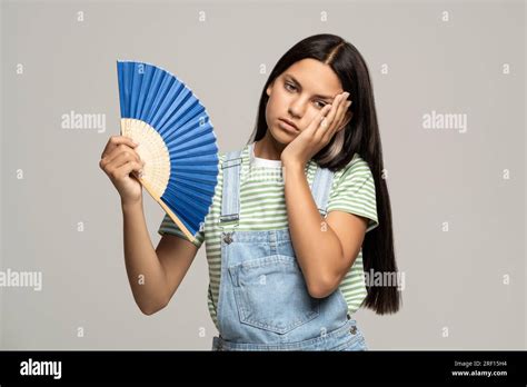 Sweaty Teenage Girl Touching Forehead Using Paper Fan Suffer From Heat Cooling In Hot Summer