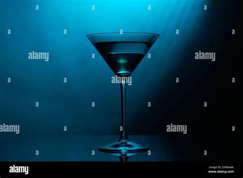 Martini glass with blue color on black background Stock Photo - Alamy