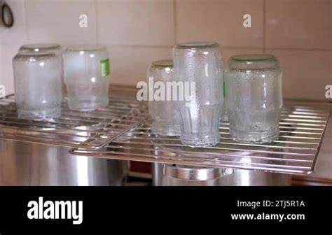 Sterilization Of Glass Jars With Hot Steam On A Metal Grate At Home In Kitchen Drops Of Water