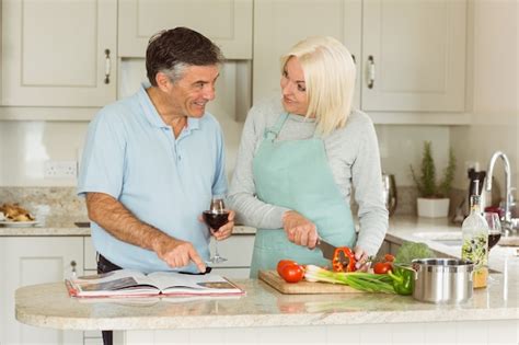 Premium Photo Happy Mature Couple Having Red Wine While Making Dinner