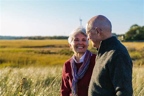 Happy Senior Couple Smile Together On Autumn Walk By Stocksy