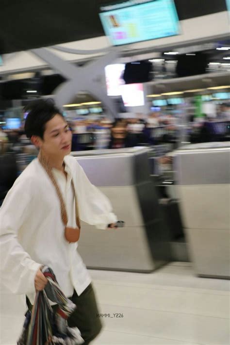 A Man Is Walking Through An Airport Carrying Bags