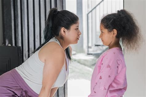 Hermosa Mujer Latina Mirando A Su Hija De Piel Morena Directamente A Los Ojos Admirando Foto