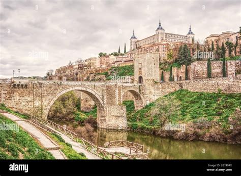 Cityscape Of Toledo In Spain With Tagus River And Roman Bridge Puente