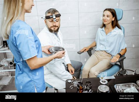 Patient With Senior Otolaryngologist And Female Assistant In Ent Office