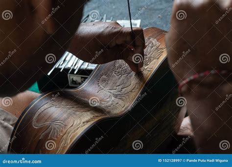 A Guitar Craftsman Are Carving A Classical Guitars Made From Wood With Balinese Pattern In A