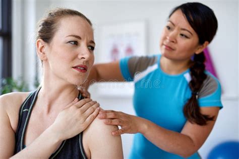 Chinese Woman Massage Therapist Giving A Treatment To An Attractive