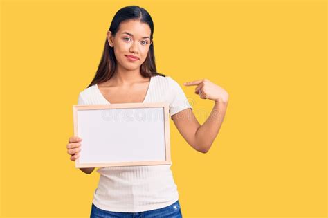 Jovem Linda Latina Segurando Um Quadro Branco Vazio Apontando O Dedo Para Um Autosorrindo Feliz