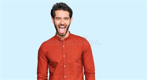 Young Hispanic Man Wearing Casual Clothes Sticking Tongue Out Happy