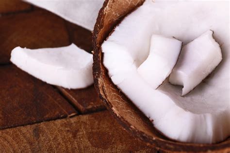 Premium Photo Broken Coconut On Wooden Background