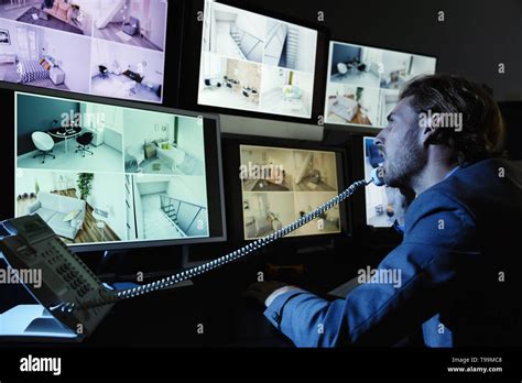 Security Guard Monitoring Modern Cctv Cameras In Surveillance Room