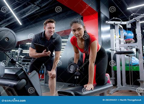 Caucasian Man Trainer Guidance and Asian Woman Lifting Dumbbell with ...