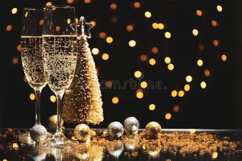 Champagne Glasses And Baubles Against Blurred Lights Background Stock