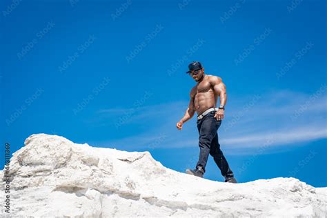 Athletic Fit Model With Naked Torso Strong Handsome Man Walking On Blue Sky Background Stock