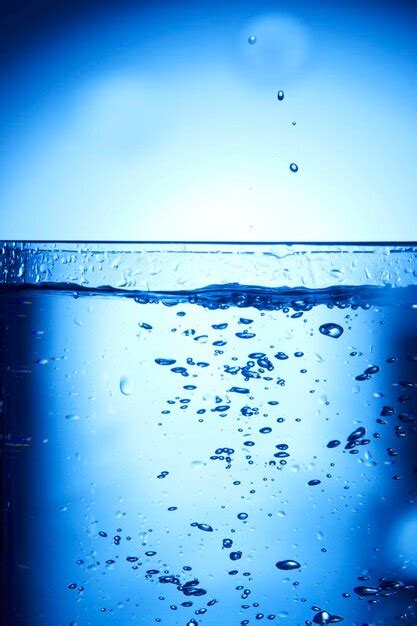 Premium Photo Drops Of Water Falling Into Deep Blue Water