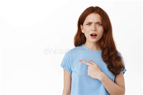 Confused And Upset Redhead Girl Complaining At Logo Banner Pointing Finger Left Frowning And