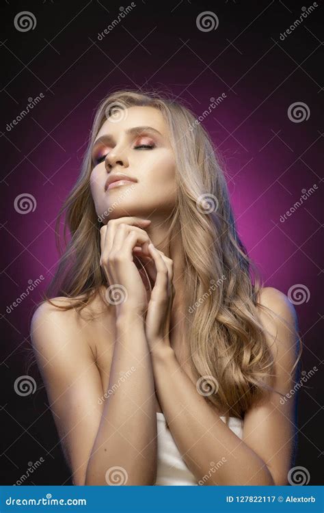 Beautiful Blonde Smiling Model Girl With Naked Shoulders And Closed Eyes Touches Her Face With