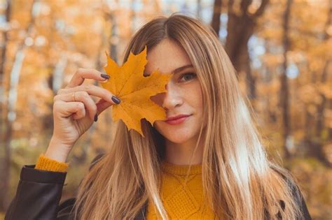 Premium Photo Young Woman With Autumn Orange Maple Leaf Over Fall