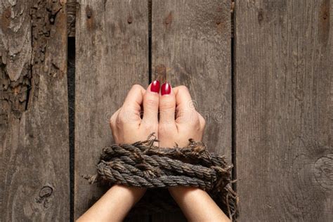 Main Femelle Attachée Avec Une Vieille Corde Sur Fond De Panneau En