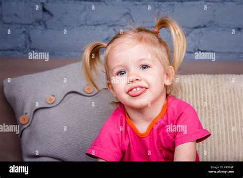 Portrait d un peu drôle fille blonde avec des yeux bleus et une drôle de coiffure dabbles et