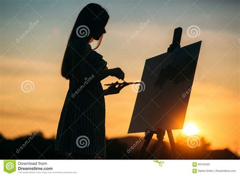 Silueta De Una Muchacha La Muchacha Del Blonde Pinta Una Pintura En La Lona Con La Ayuda De Las