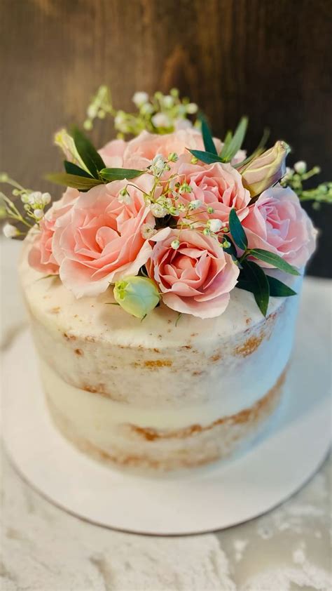 Naked Wedding Cake With Pink Flowers And Greenery