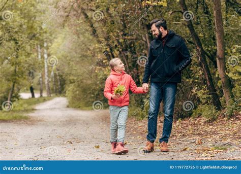 Padre Feliz E Hija Que Llevan A Cabo Las Manos Y Que Caminan Junto Foto