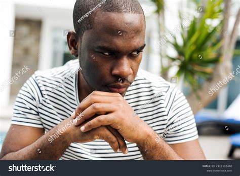 Close Portrait African Man Sitting Glancing Stock Photo 2119118468