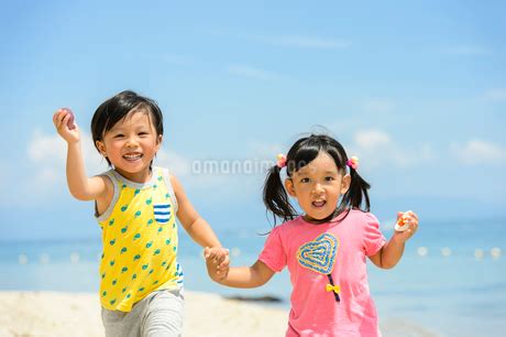 砂浜を手を繋いで走る男の子と女の子の写真素材 FYI02658161 ストックフォトの Qlean Market