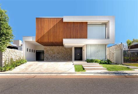 Fachada de casa contemporânea volume revestido de madeira ripada