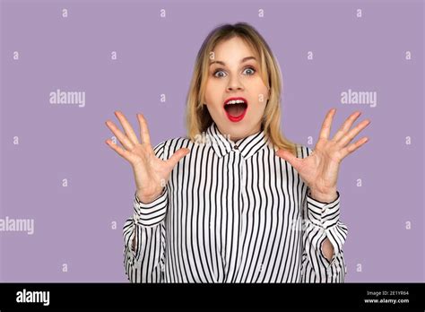 Oh mon dieu wow Excitée surprise femme blonde dans un chemisier rayé debout la bouche ouverte