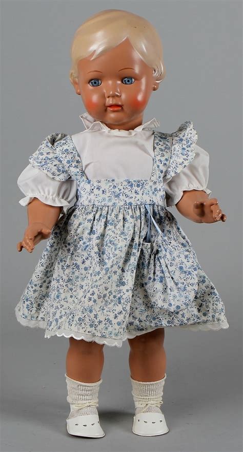 An Old Doll With Blonde Hair And Blue Eyes