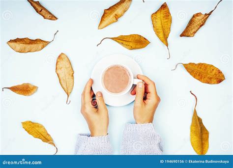 Women S Hands Hold A Cup With Coffee Against The Background Of Autumn