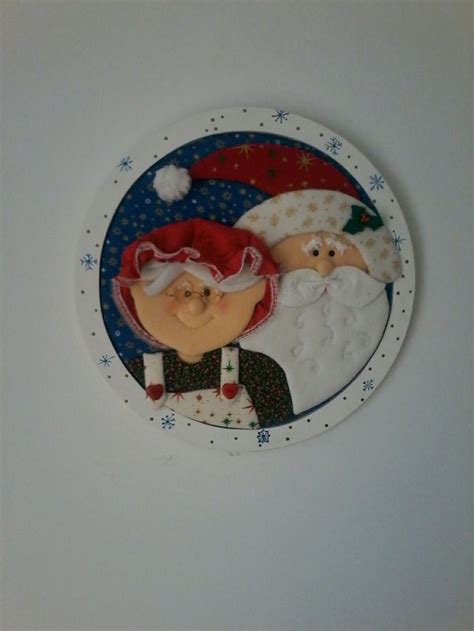 A Christmas Ornament With Santa And Mrs Claus In The Snow On It S Side