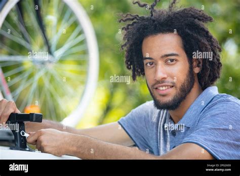 man fixing roof bars on top of his car Stock Photo - Alamy