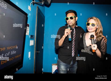 Happy couple singing karaoke while standing in nightclub Stock Photo ...