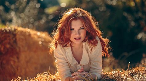 Redhead Girl Model Is Lying Down On Dry Grass Wearing White Dress In