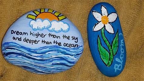 Two Painted Rocks With Words And Flowers On Them One Saying Dream