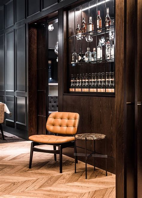 A Chair And Table In A Room With Liquor Bottles On The Wall Behind It