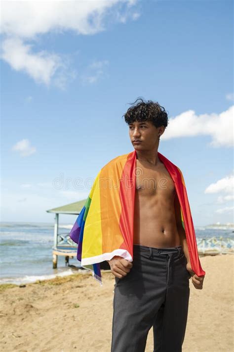 Joven Gay Mirando De Lado Orgulloso Con La Bandera De Lgbt Colgando De Sus Hombros Imagen De